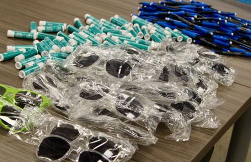 sunglasses, lip balm, and ink pens sitting on a table